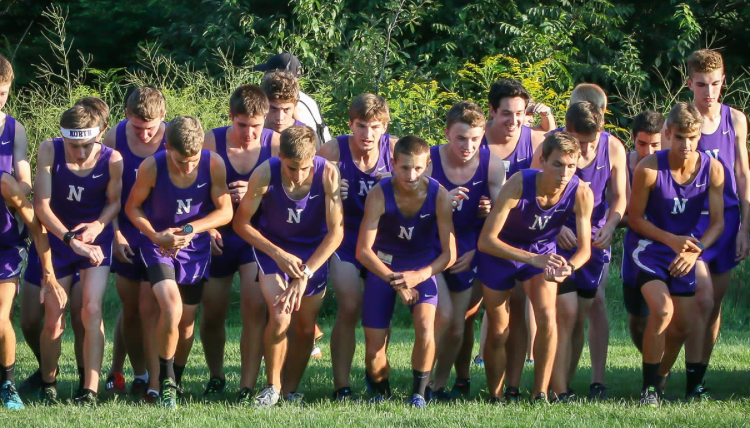 RUNNING FOR THE RANKING: The boys cross country team starts their watches at the beginning of the St. Charles Leavey Invite on Sept. 3 in St. Charles. The watches help the boys pace themselves throughout the race and push them to beat their personal bests. The team finished first with a total of 73 points.