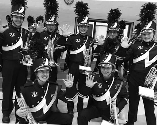 SAY CHEESE: Marching band members pose to show off their hot pink gloves and ribbons on Friday, Oct. 7.