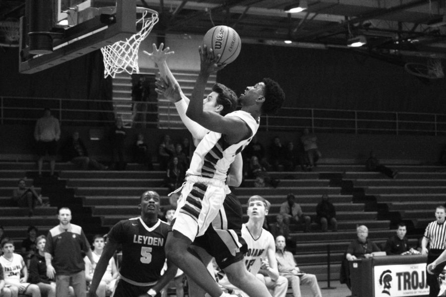 GETTIN’ UP: Colin Reed (12) pushes to the basket to complete layup as Noah May (42) and DaQuan Harris (5) wait under the rim for the rebound.