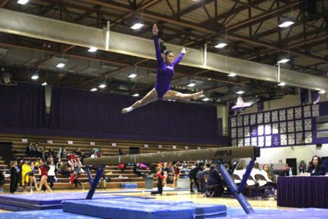 BIG AIR: Lauren Lucina (12) leaps on the beam during a meet. Lucina placed 3rd  for the Trojans on beam during the 2019 Regional competition. 
