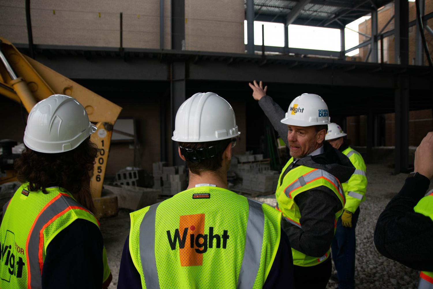 Associate Principal Dr. Ken Sorensen gestures towards the upper floors of the site.