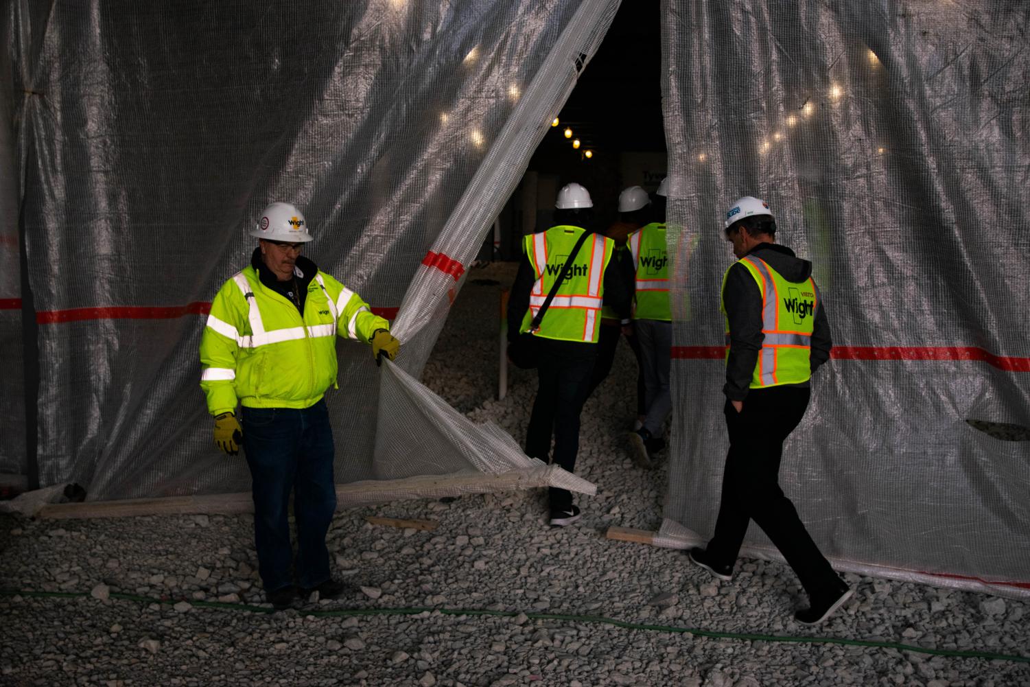 Wight Construction Field Safety Director, Michael Lynch, holds open the safety net allowing the Omega's entry into the site.