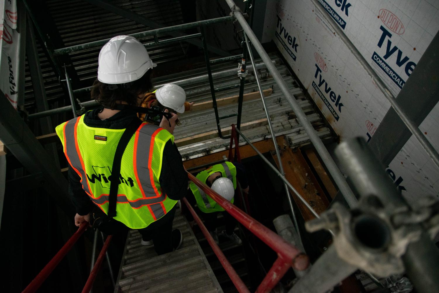 The visiting Omega staff members descend the temporary staircase where the new student elevator will be. This new elevator will go all the way from the third floor down to the underground track.