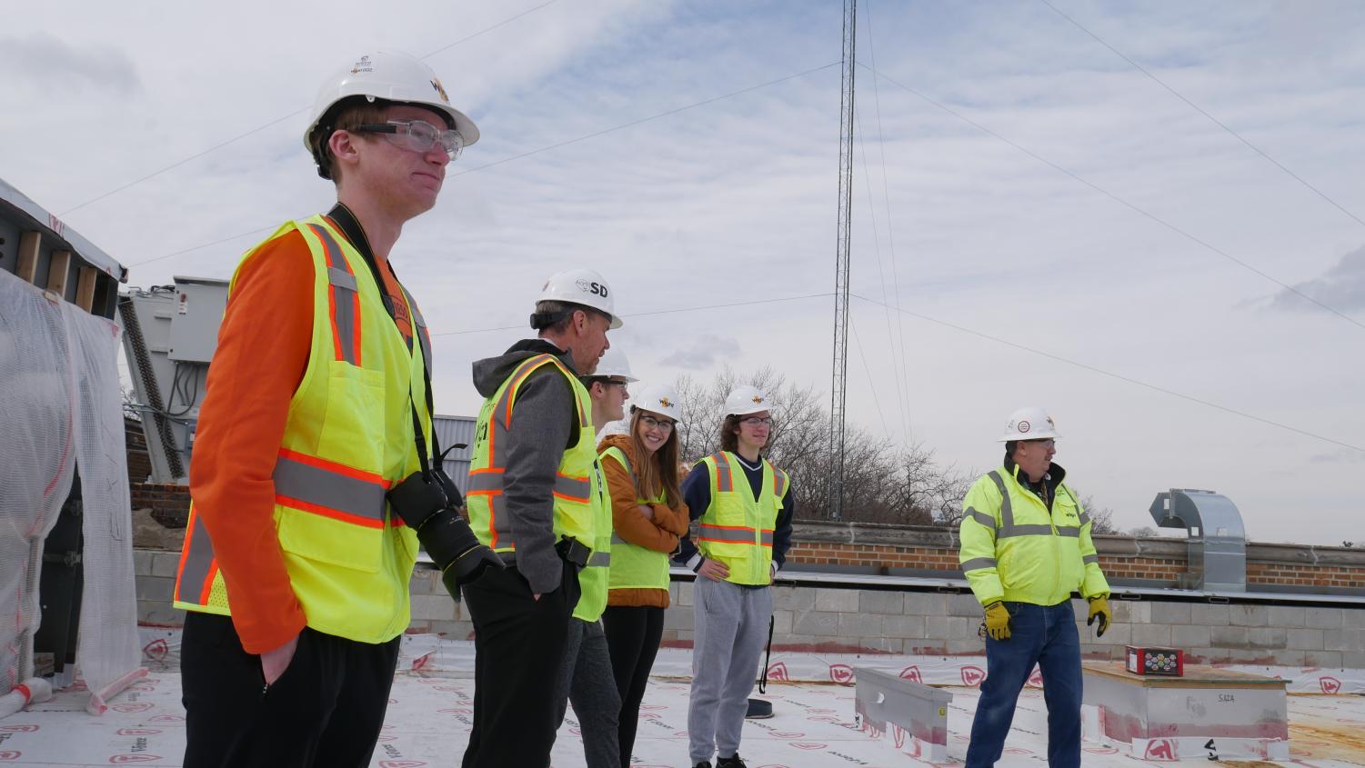 Omega staff members observe the construction from the roof.