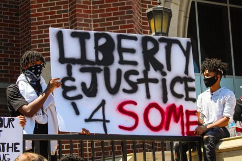 THE FIGHT FOR EQUALITY: two young men hold a sign reading Liberty and Justice 4 Some at a BLM march in Downers Grove last summer.