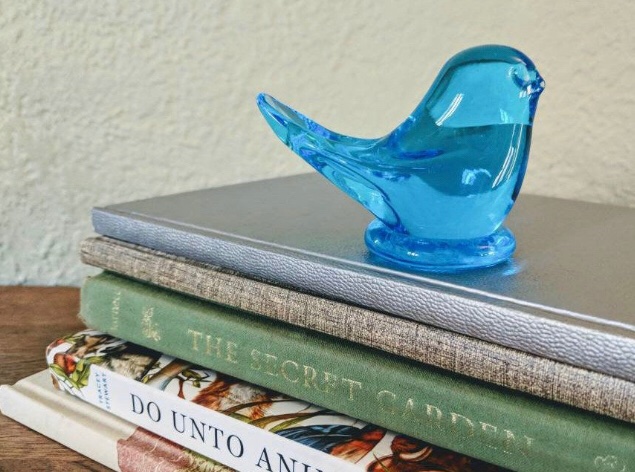 BALLAD OF THE BLUEBIRD: Perched on top of a stack of books is a bluebird figurine, gifted to Madeline Riske by her grandmother.