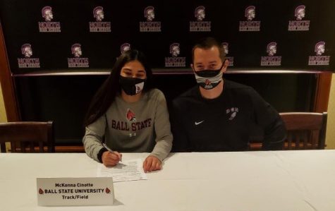 SIGNING THE DOTTED LINE: McKenna Cinotte (12) makes her final decision in committing to Ball State University Nov. 11. She sits with Head Track and Field Coach Matthew Maletich for support of her future.