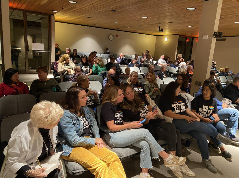 STANDING TOGETHER: Supporters of the librarys drag event attend the Wednesday night village meeting fully outfitted in We Support our Library t-shirts.