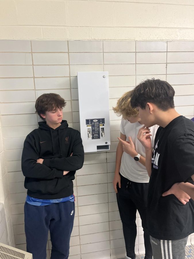 CURIOSITY STRIKES: Juniors Will Beatty, Zach Bender, and Dylan Hogg look at new dispenser. 