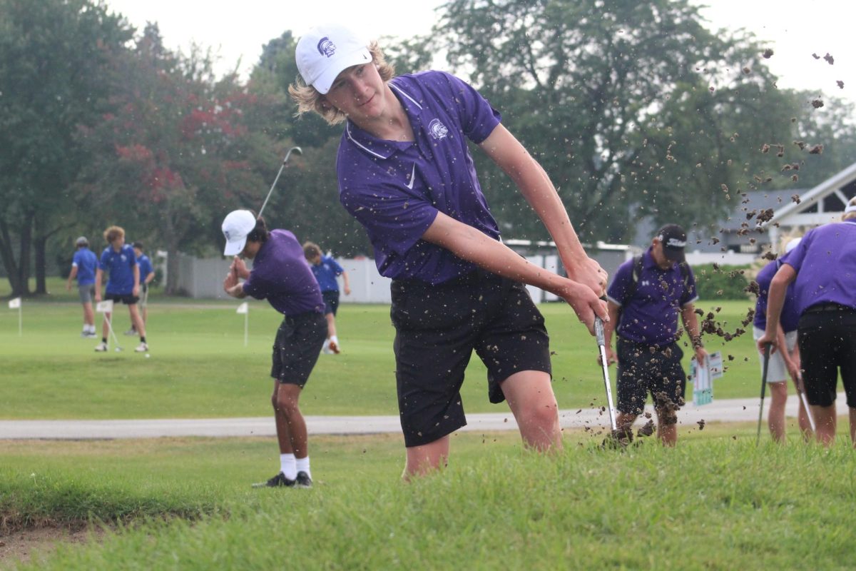 SWING FOR SUCCESS: Connor Hurst (12) prepares for his match against OPFR at Carriage Green Country Club Sept. 6. The Trojan would go on to beat OPFR, setting a new school record.  