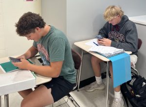 DISTRACTED STUDYING: Antonio Russotiesi (9) and Peter Carter (9) look at their phones while in a classroom.