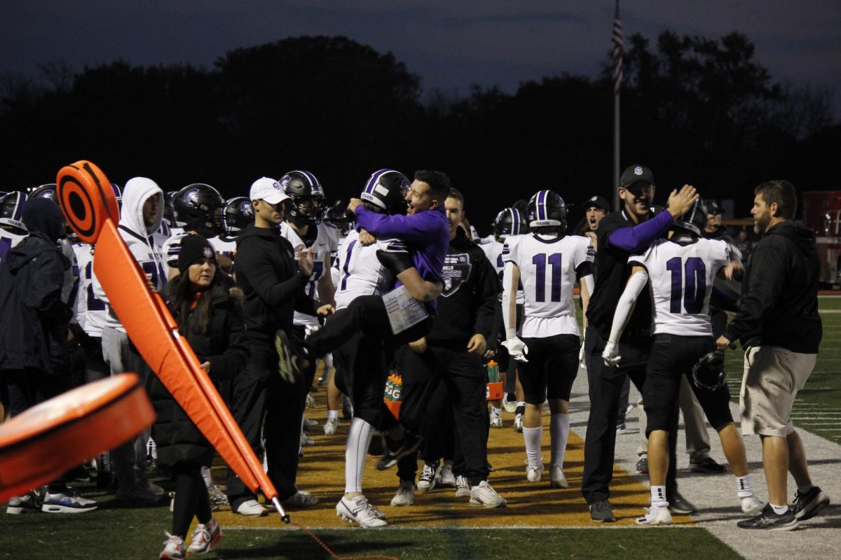 JUMPING FOR JOY: Sophomore Owen Lansu embraces Coach Croci after throwing the game winning touchdown against Hersey Nov. 4.