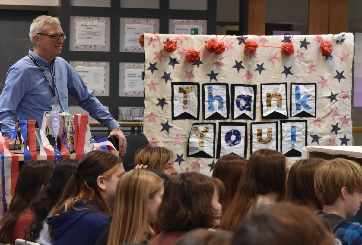 SHOWING APPRECIATION: Admiration fills the air as Social Studies chairperson Michael Roethler and his students listen intently to the veterans narrating their military experiences, a large “Thank You!” sign expressing DGN’s gratitude for their service.