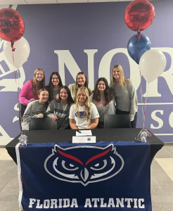 PICKING UP THE PEN: Ashlynn Durkin signs her NLI to play softball at Florida Atlantic with her teammates surrounding her in support.