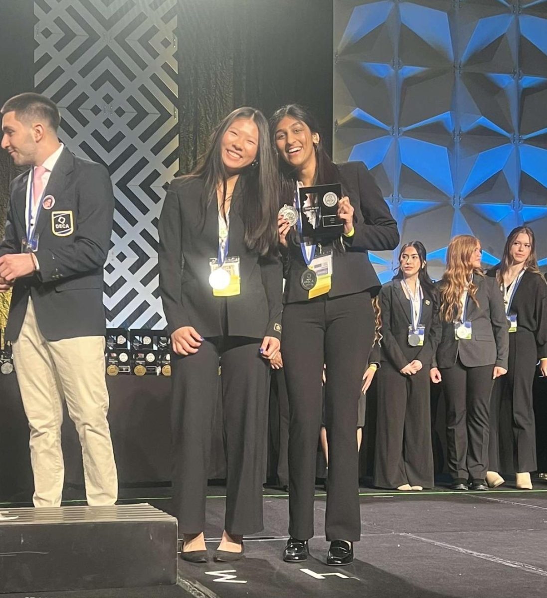 MAKE THEIR MARK: DECA members Nicole Liu (10) and Shubreet Kaur (10) hold up their plaques after qualifying for ICDC.